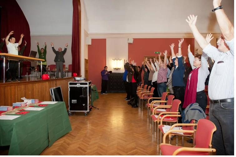 Participants of an information event stretching their arms upwards during an exercise